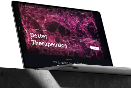 Laptop showing a biotech website with a bold 'Better Therapeutics' headline